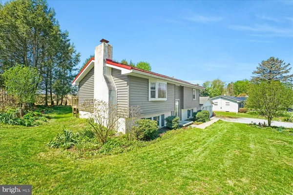 a view of backyard of house with wooden fence