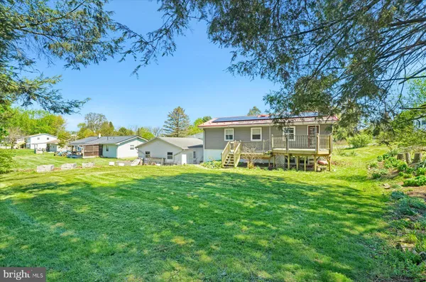 a view of a house with a big yard and large trees