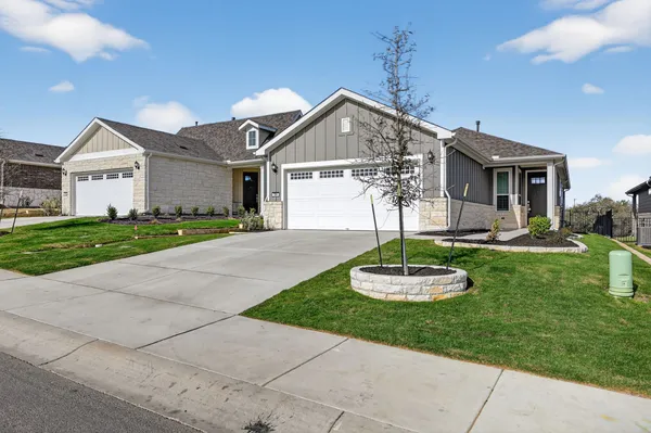 a front view of a house with a yard and a garage