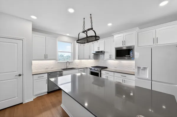 a kitchen with stainless steel appliances granite countertop a sink a stove and cabinets
