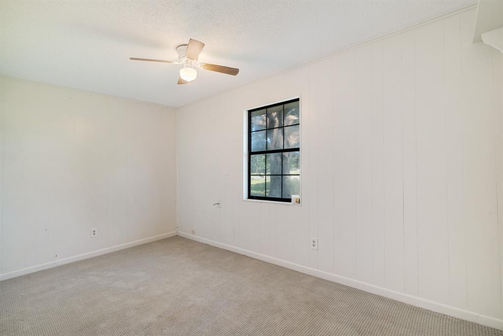 3875 Highway 271 Powderly, TX 75473 - Photo 14 of 25 an empty room with a window and ceiling fan