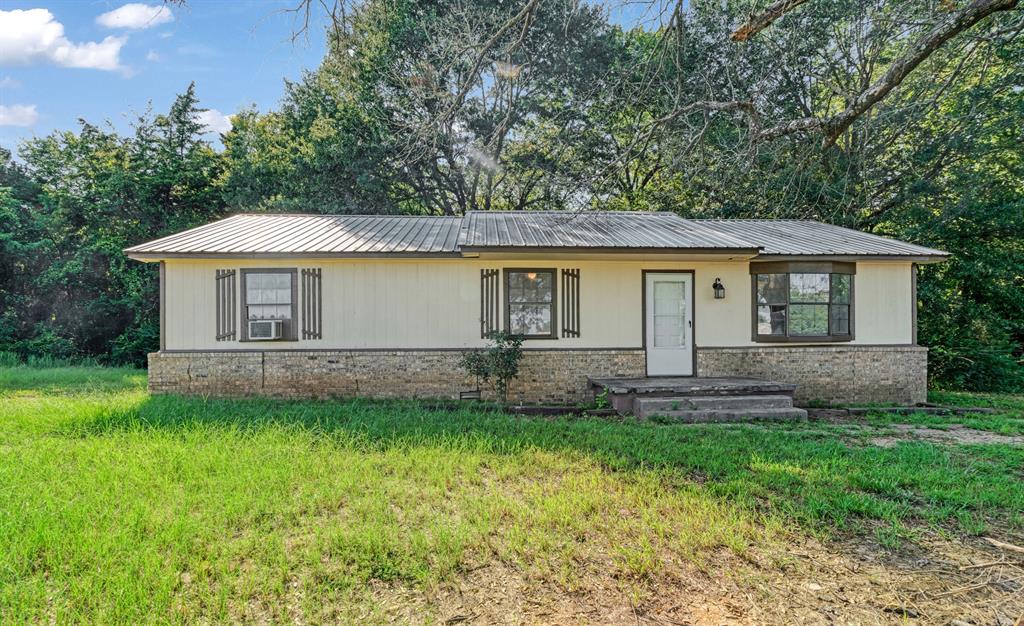3875 Highway 271 Powderly, TX 75473 - Photo 4 of 25 a front view of a house with a garden