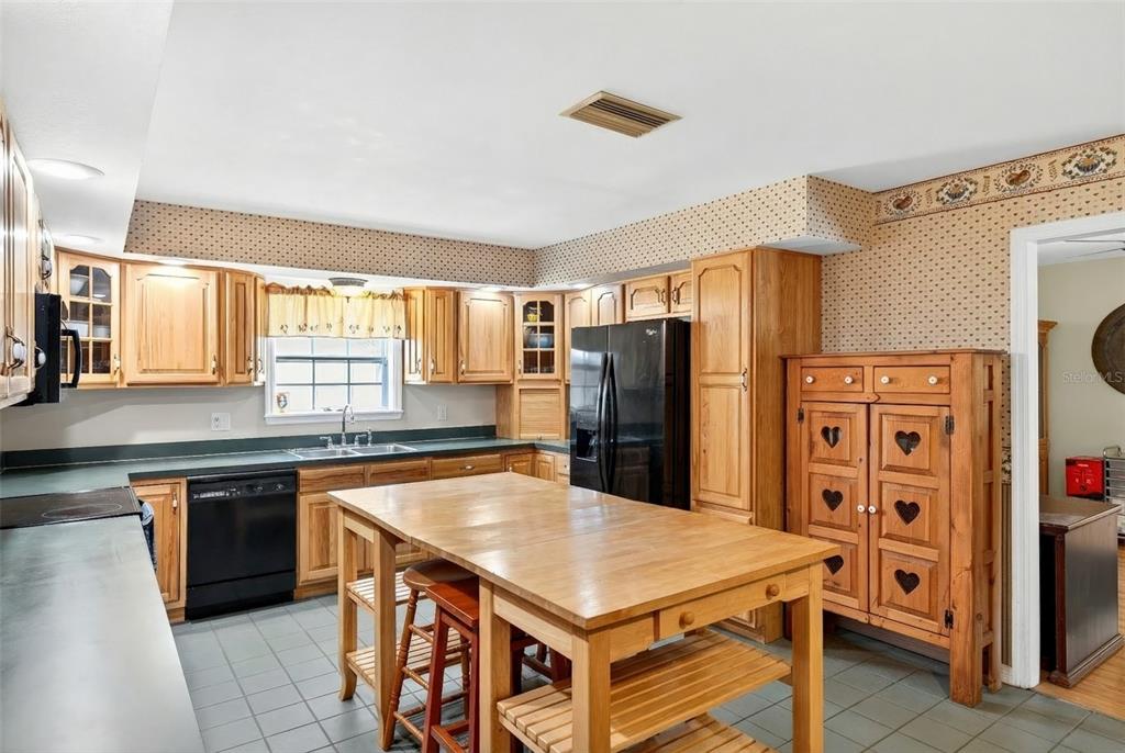 5940 Northeast 57th Loop Silver Springs, FL 34488 - Photo 19 of 44 a kitchen with stainless steel appliances a table chairs and a refrigerator