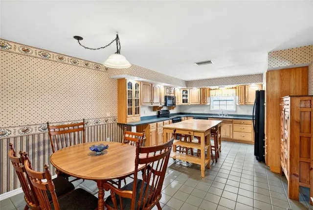 a dining room with a table chairs and a kitchen view