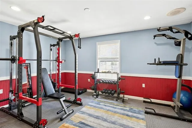 a room with gym equipment and wooden floor