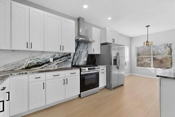 a kitchen with stainless steel appliances granite countertop a stove a refrigerator and a sink