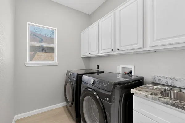 a utility room with sink dryer and washer
