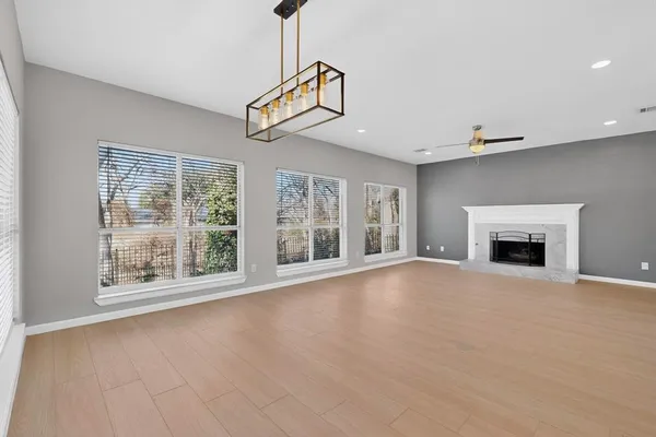a view of an empty room with a fireplace and a window