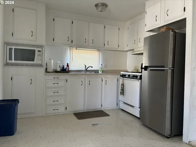 a kitchen with white cabinets and white appliances