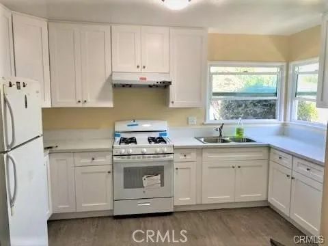 a kitchen with white cabinets and white appliances