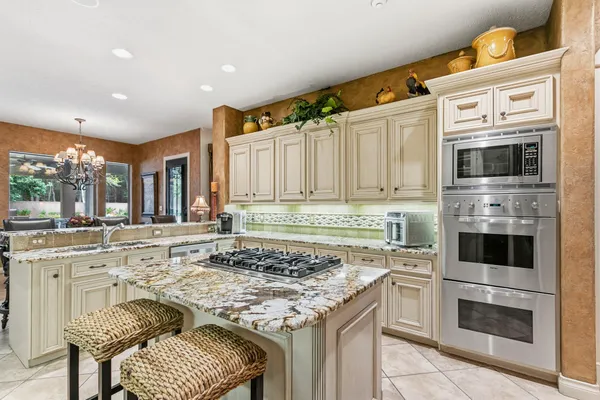 a kitchen with stainless steel appliances kitchen island granite countertop a table and chairs in it