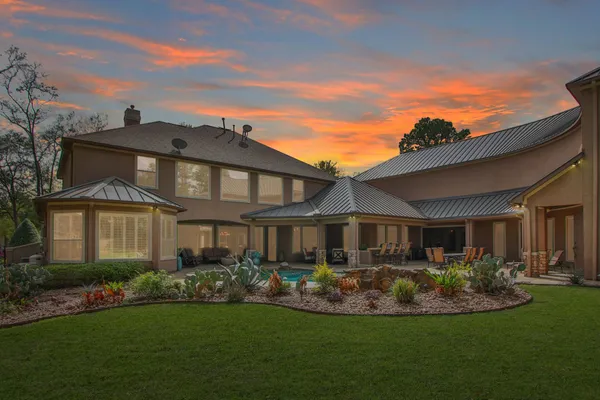 a front view of a house with a yard and potted plants