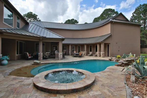 a view of a lake with couches and chairs under an umbrella