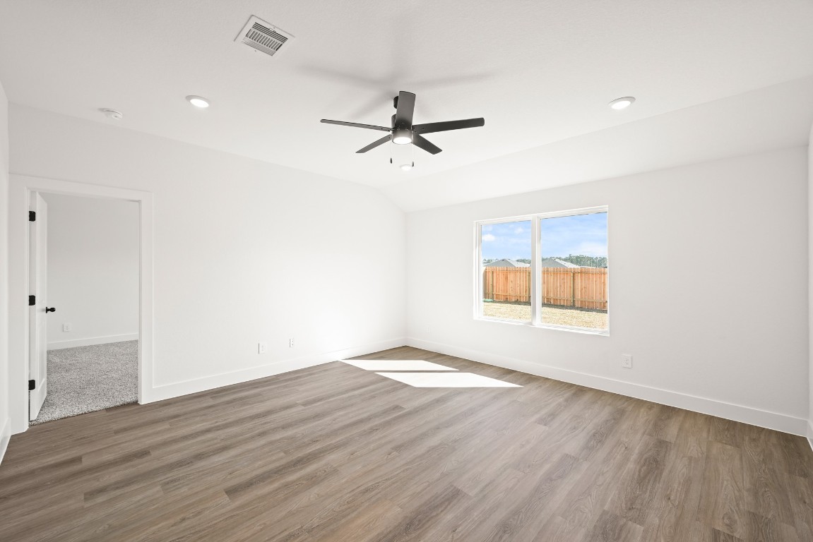 15775 Hanson Ridge Drive Montgomery, TX 77316 - Photo 9 of 33 an empty room with wooden floor ceiling fan and windows