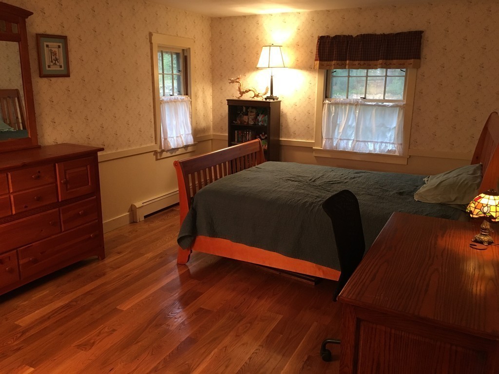 3333 Diamond Hill Road Cumberland, RI 02864 - Photo 20 of 29 a bedroom with a bed and wooden floor