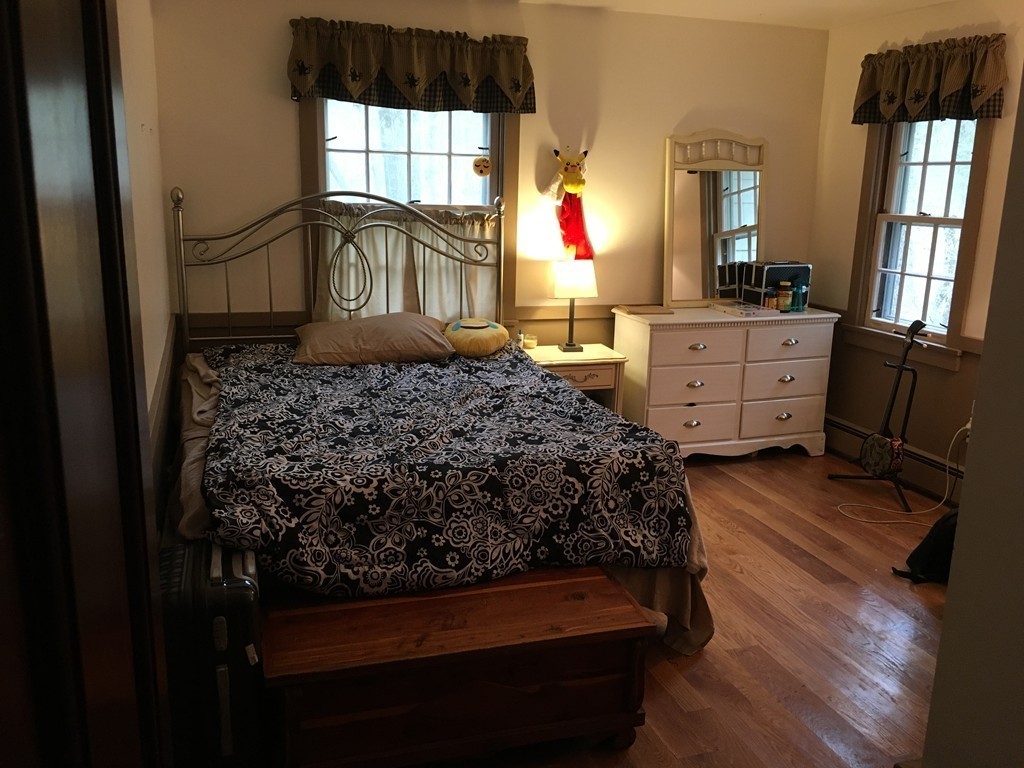 3333 Diamond Hill Road Cumberland, RI 02864 - Photo 21 of 29 a bedroom with a bed dresser mirror and a window