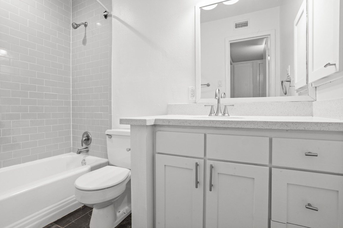 3602 Garrott Street, Unit 7 Houston, TX 77006 - Photo 24 of 34 The remodeled bath has a tub shower combo with slate floors.
