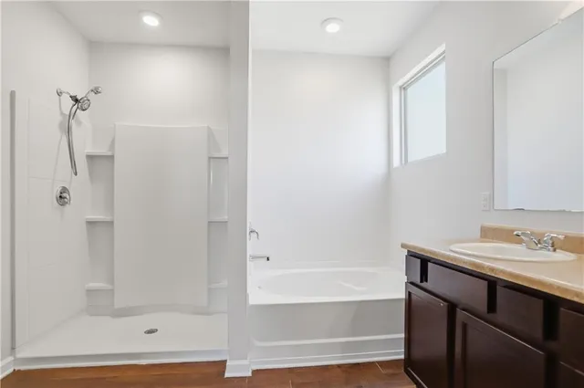 a bathroom with a bathtub sink vanity and mirror