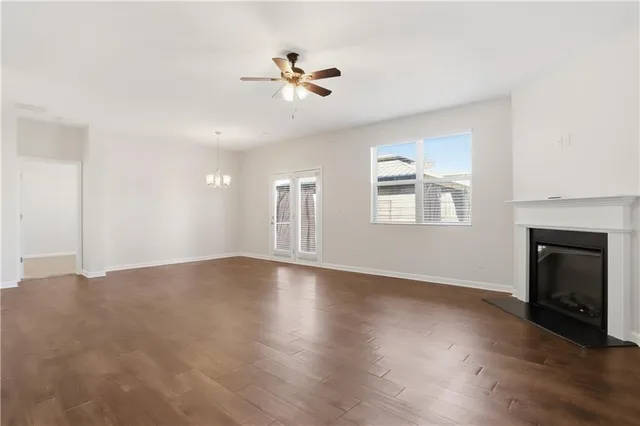 a view of an empty room with a fireplace and wooden floor