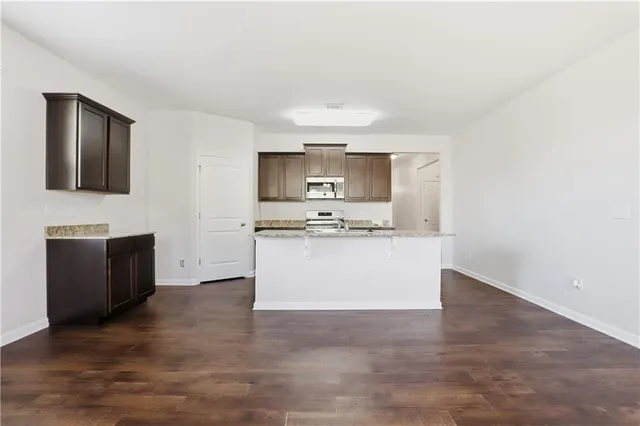 a view with kitchen island microwave stove and cabinets