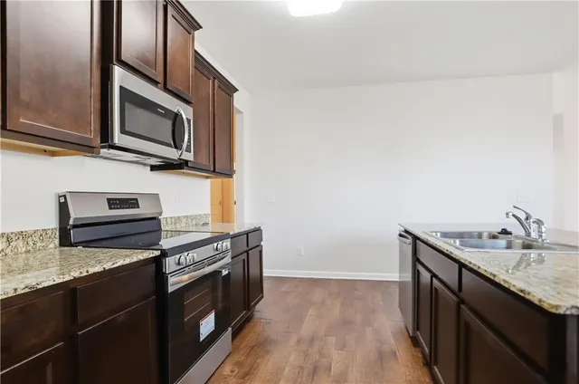 a kitchen with stainless steel appliances granite countertop a sink stove and microwave