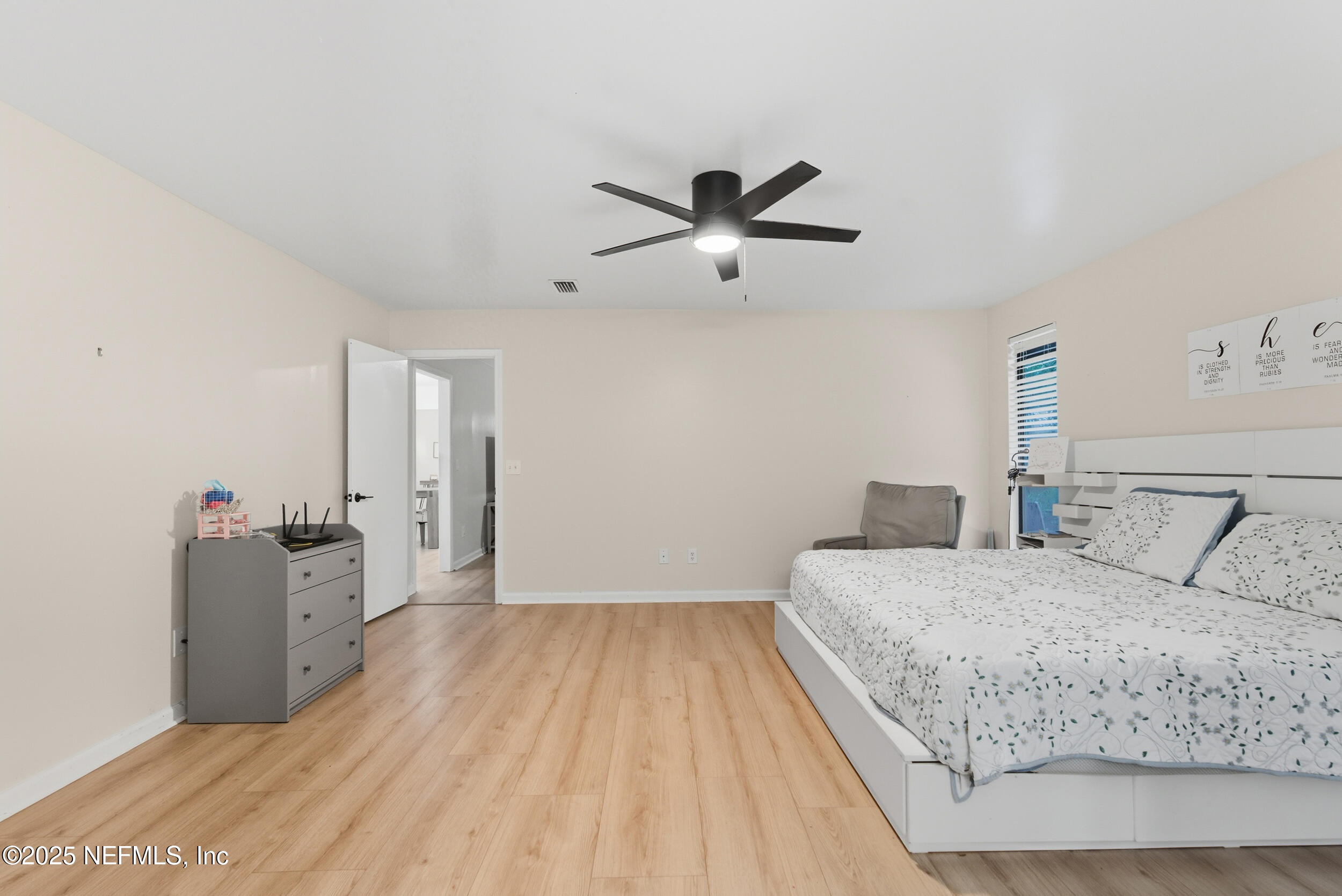 11238 McCormick Road Jacksonville, FL 32225 - Photo 17 of 25 a bedroom with a large bed and a chandelier