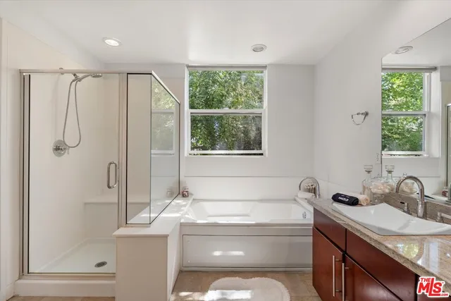 a bathroom with a granite countertop sink toilet and shower