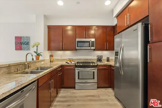 a kitchen with stainless steel appliances granite countertop a sink stove and refrigerator