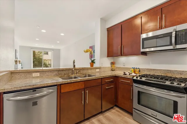 a kitchen with stainless steel appliances granite countertop a sink stove and microwave