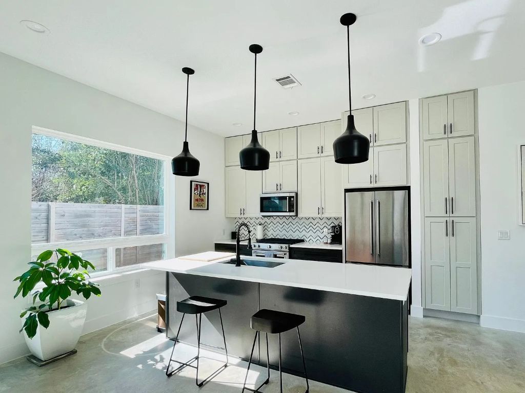 910 Gullett Street, Unit 2 Austin, TX 78702 - Photo 5 of 19 Kitchen featuring concrete floors, high quality appliances, hanging light fixtures, a kitchen island with sink, and tasteful backsplash