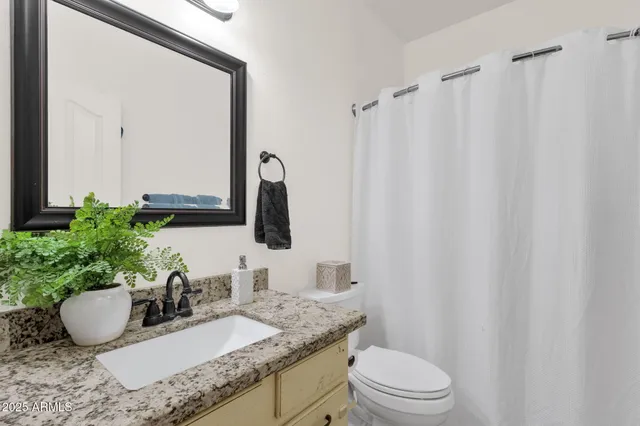 a bathroom with a granite countertop sink double and mirror