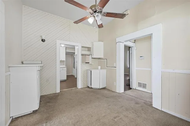 a view of a kitchen with a refrigerator and a chandelier fan