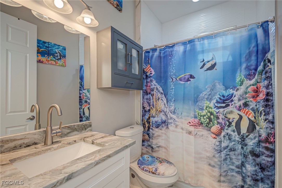 3309 30th Street Southwest Lehigh Acres, FL 33976 - Photo 11 of 28 a bathroom with a granite countertop sink and a mirror
