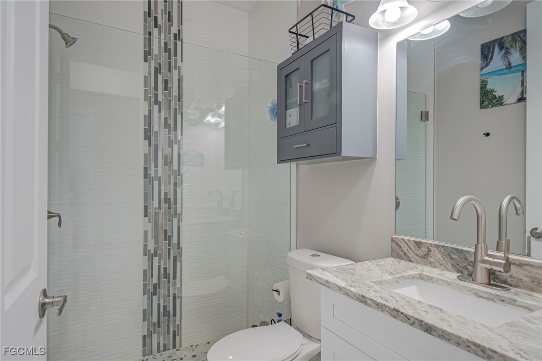 3309 30th Street Southwest Lehigh Acres, FL 33976 - Photo 13 of 28 a bathroom with a granite countertop sink a mirror and a shower