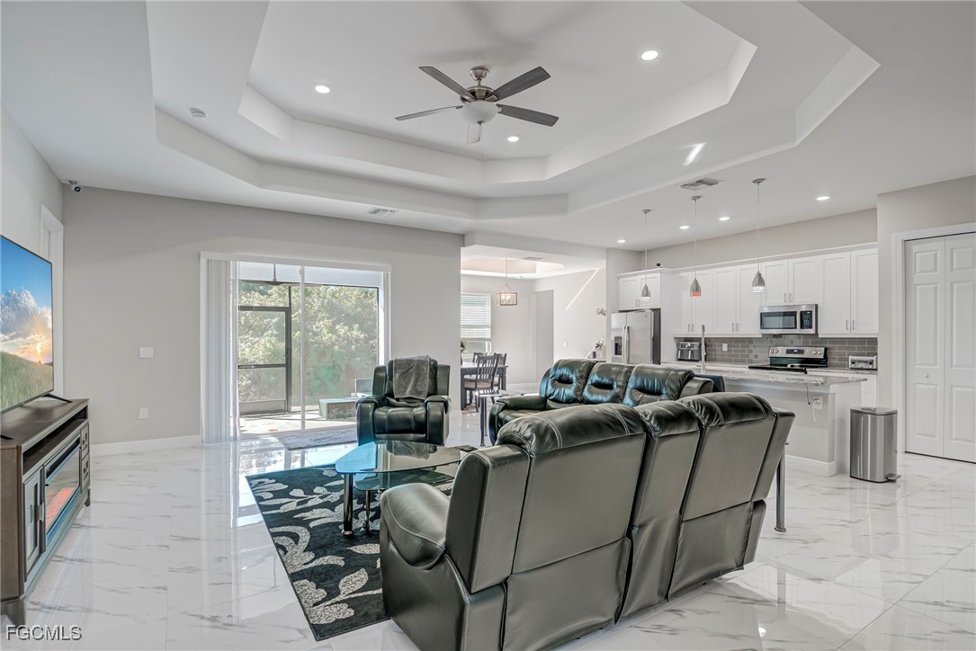 3309 30th Street Southwest Lehigh Acres, FL 33976 - Photo 2 of 28 a living room with furniture kitchen area and a large window