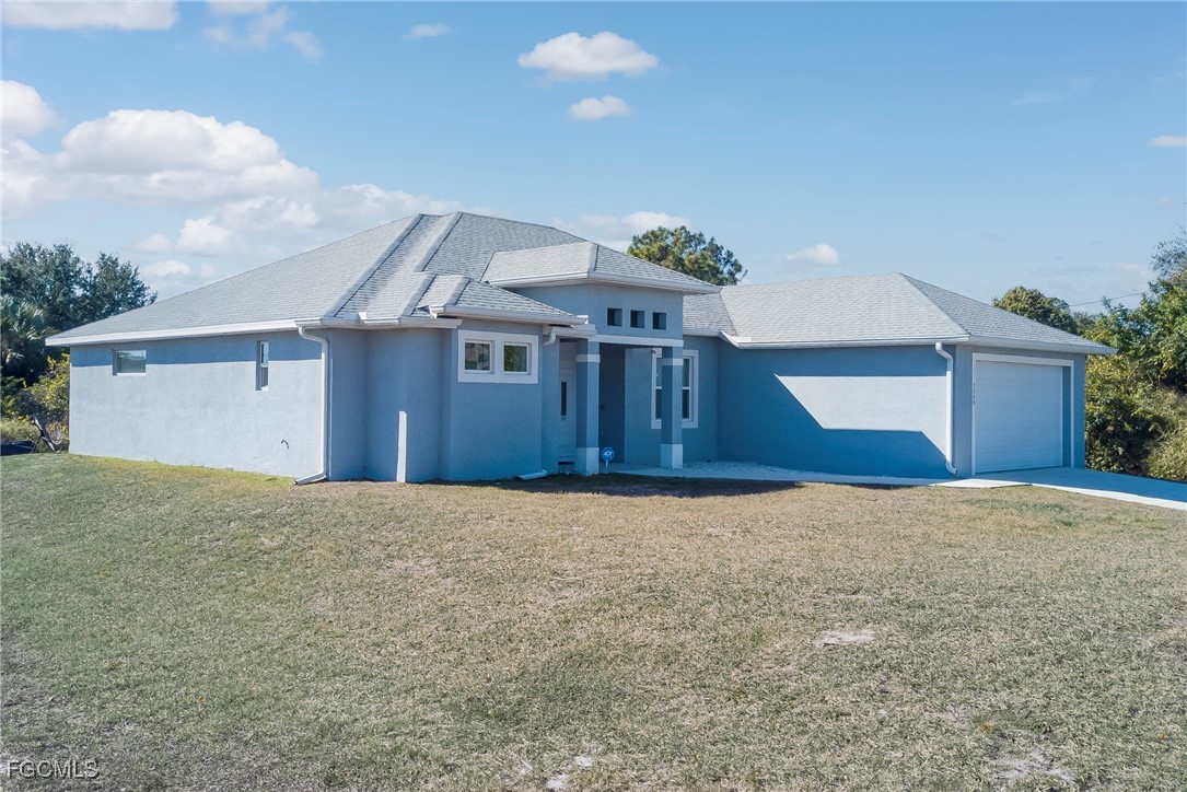 3309 30th Street Southwest Lehigh Acres, FL 33976 - Photo 22 of 28 a front view of a house with a yard and garage