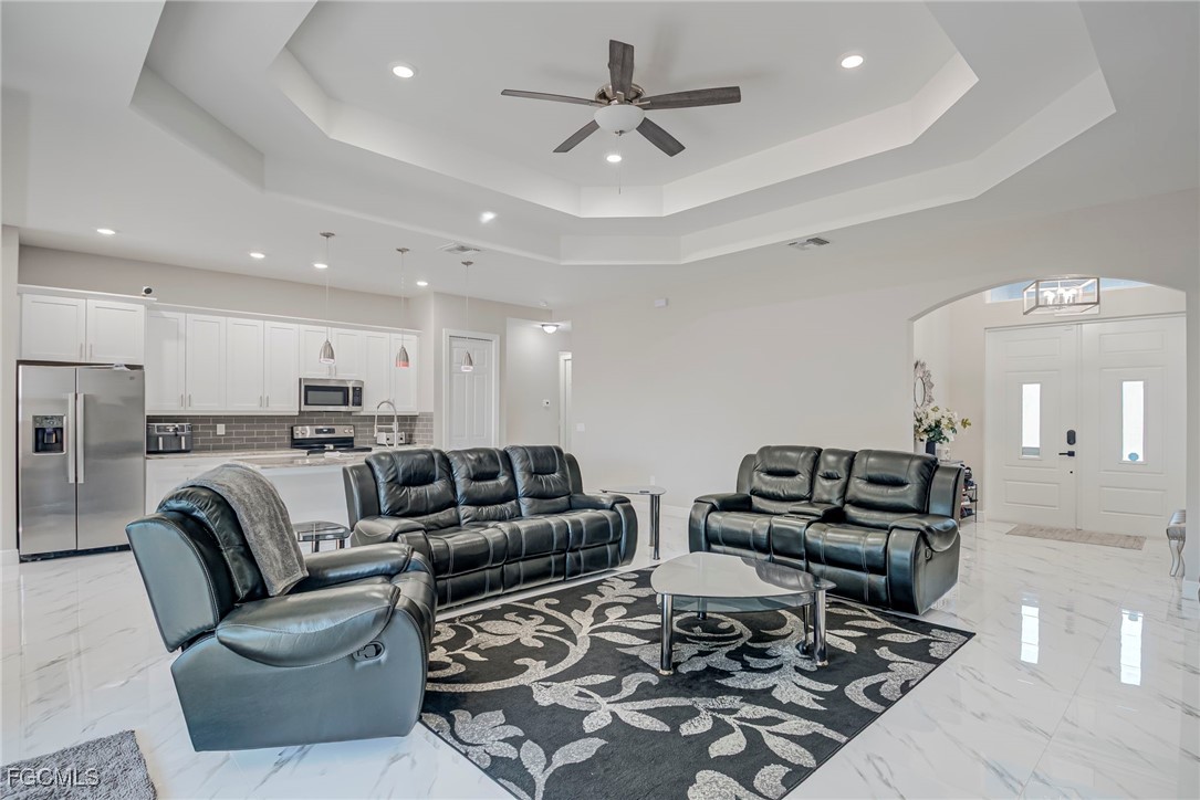 3309 30th Street Southwest Lehigh Acres, FL 33976 - Photo 3 of 28 a living room with furniture and a chandelier