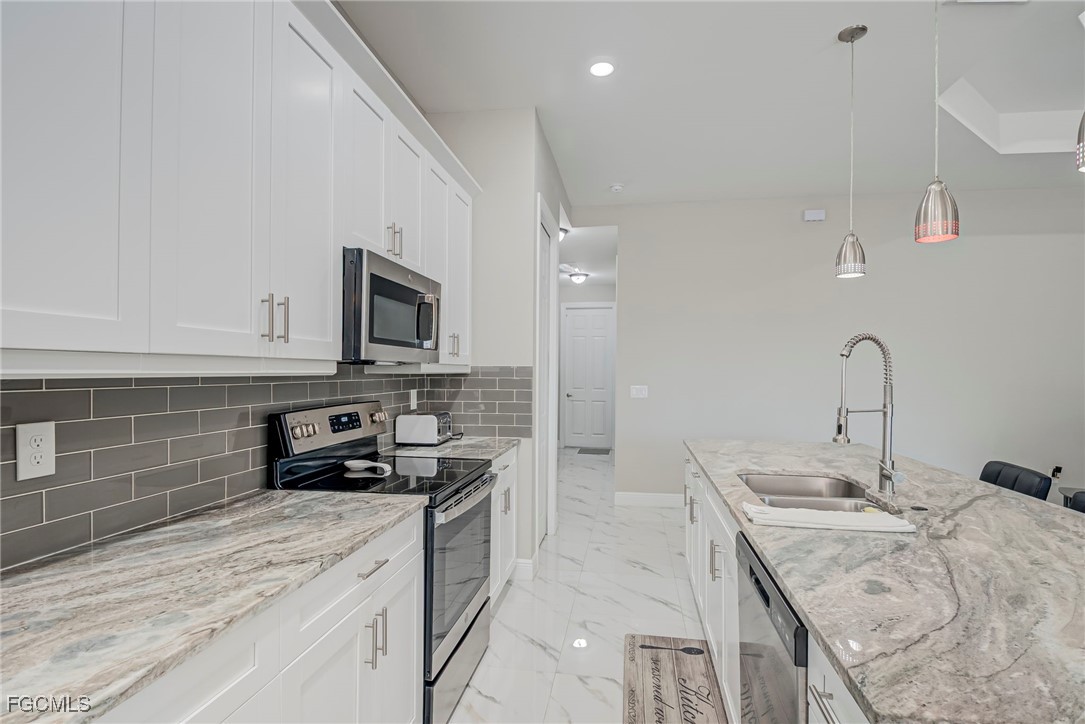3309 30th Street Southwest Lehigh Acres, FL 33976 - Photo 8 of 28 a kitchen that has a sink and a stove
