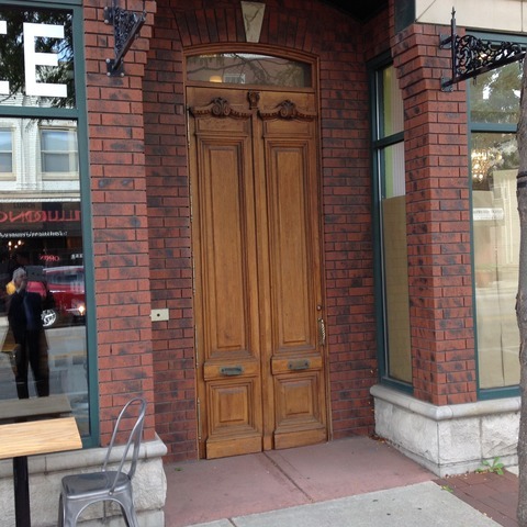a brick building with a door and a chair
