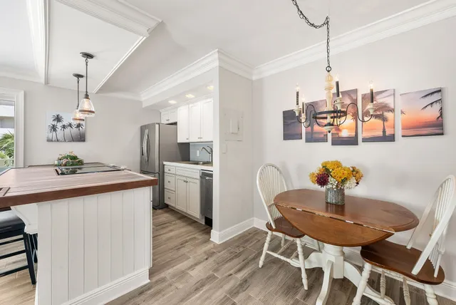 a kitchen with a dining table chairs and white appliances