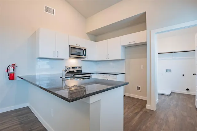 a kitchen with granite countertop a sink and a stove top oven