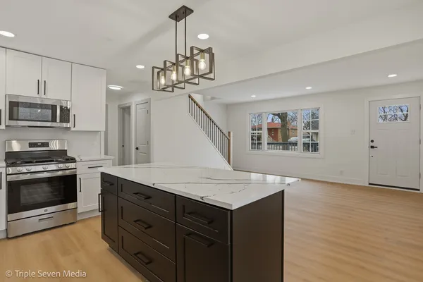 a kitchen with a sink a stove and chairs