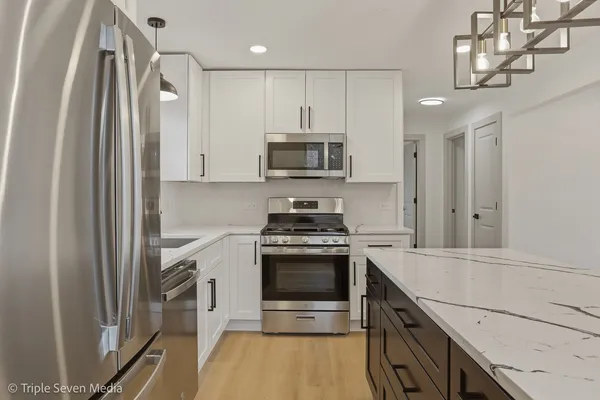 a kitchen with stainless steel appliances a sink and a refrigerator