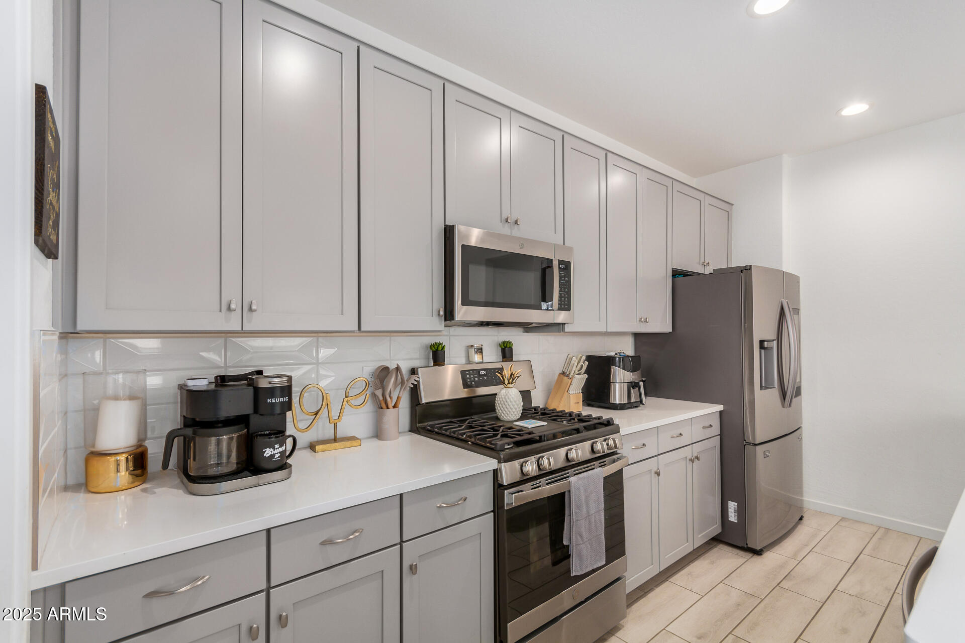 13319 West Red Range Way Peoria, AZ 85383 - Photo 15 of 38 a kitchen with stainless steel appliances granite countertop white cabinets stove a sink and dishwasher