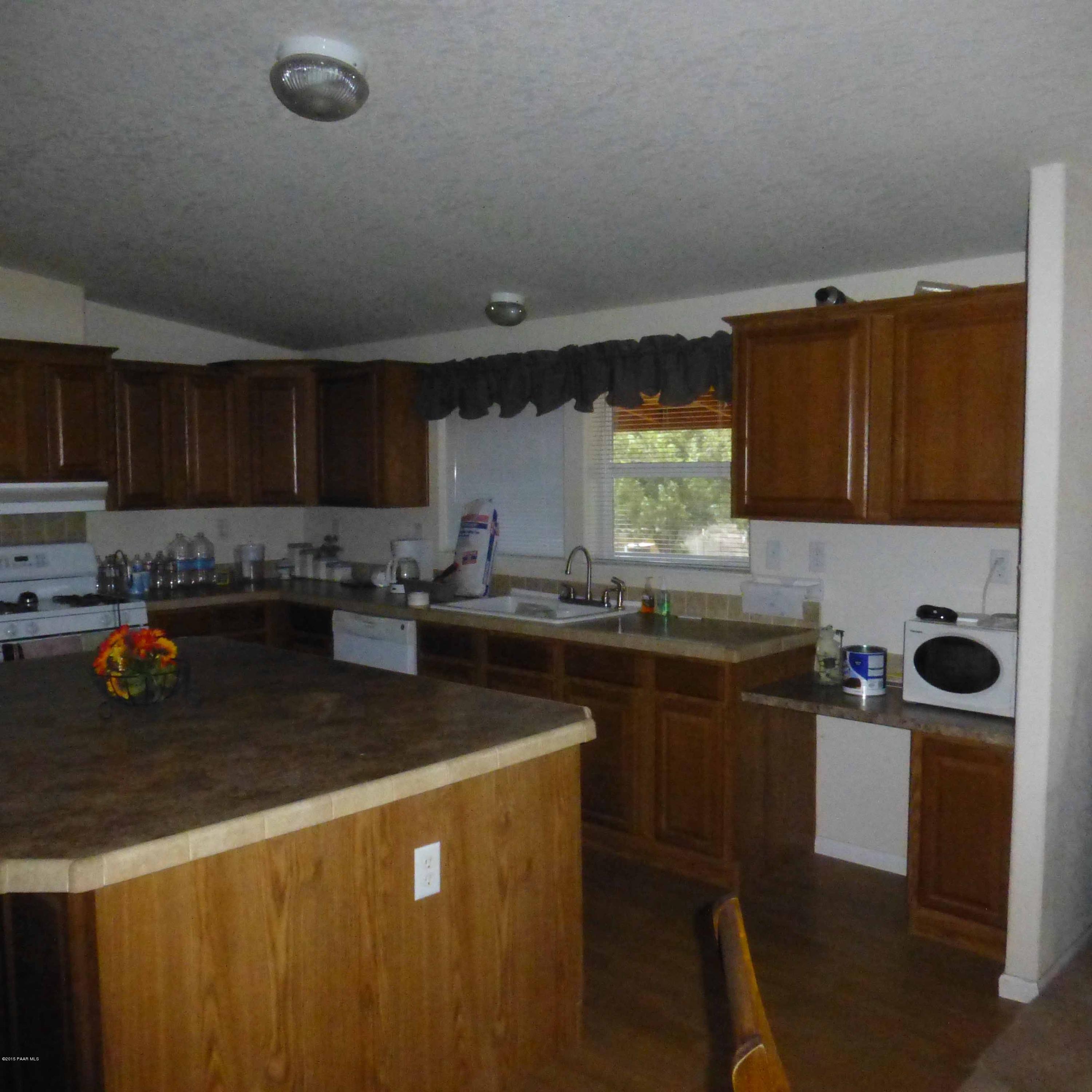 3893 Verde Road Ash Fork, AZ 86320 - Photo 6 of 33 a kitchen with stainless steel appliances granite countertop a sink a stove a refrigerator a counter space and cabinets