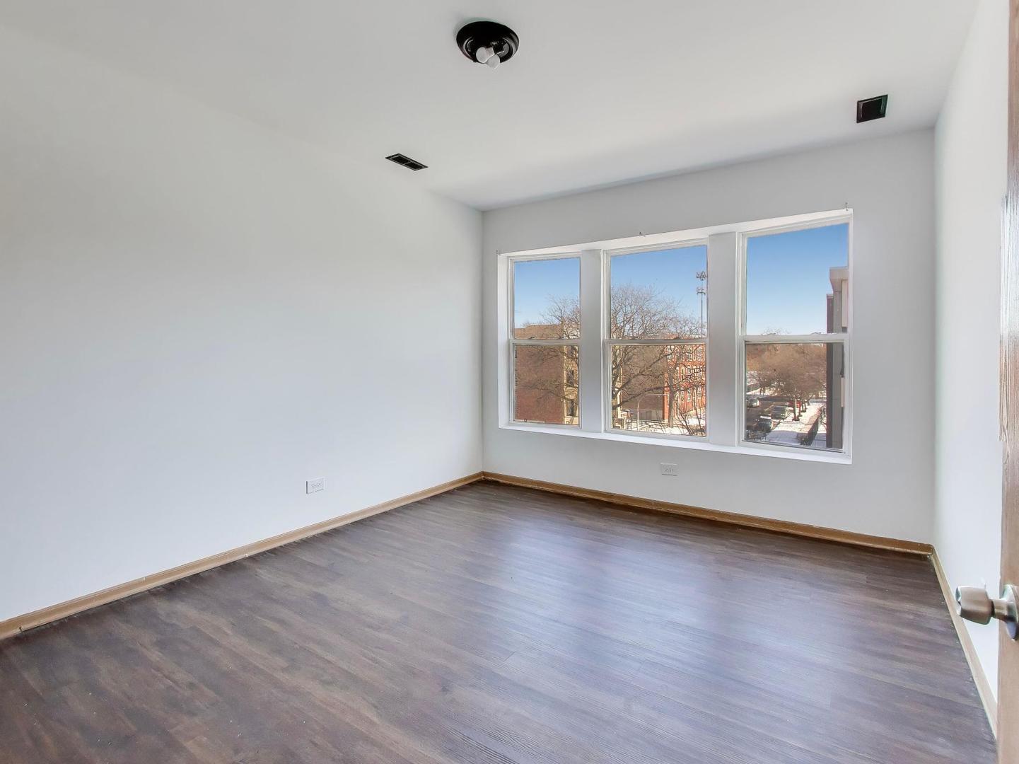 5000 South Champlain Avenue, Unit 3 Chicago, IL 60615 - Photo 13 of 17 a view of an empty room with wooden floor and a window