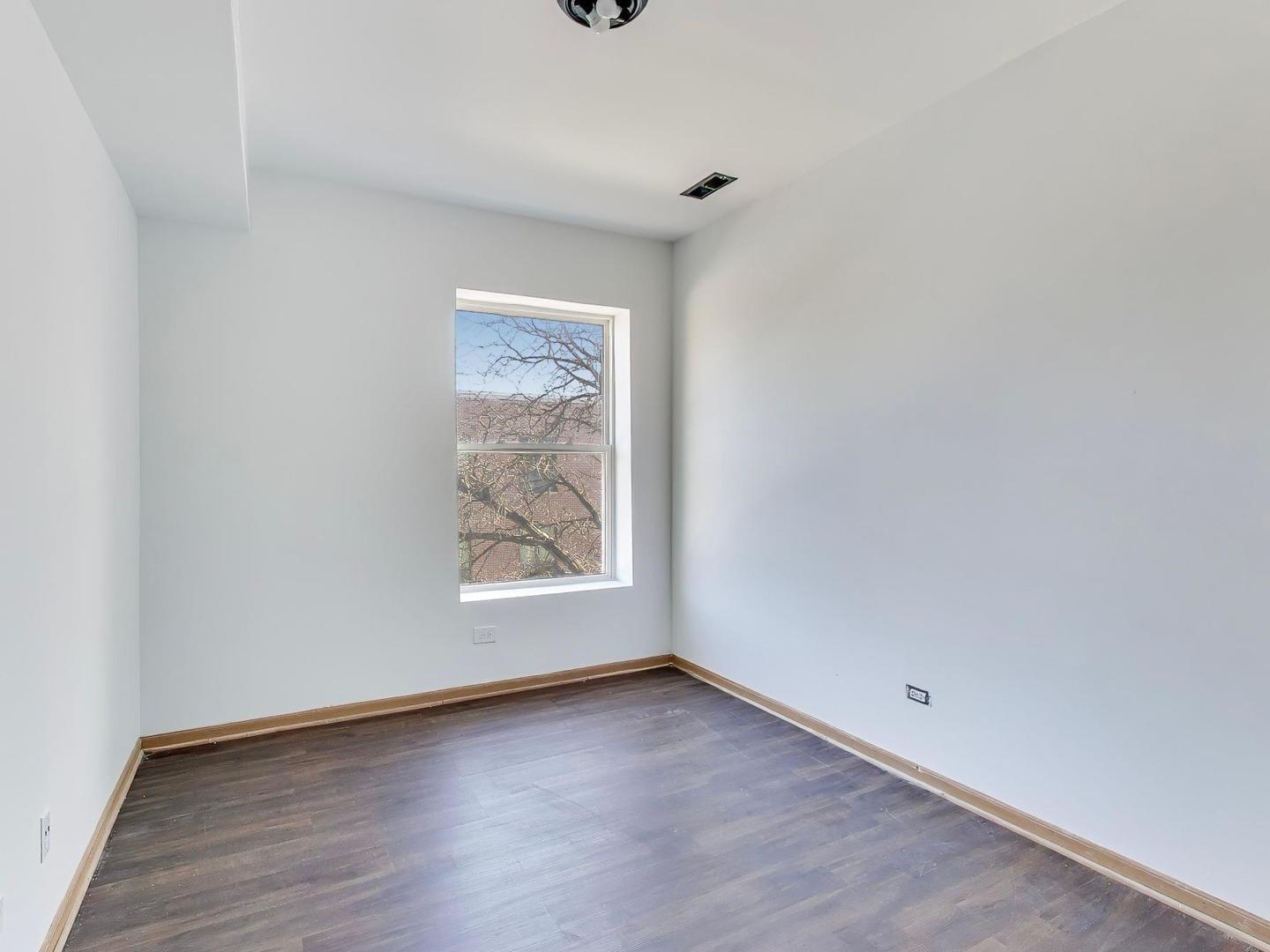 5000 South Champlain Avenue, Unit 3 Chicago, IL 60615 - Photo 16 of 17 an empty room with wooden floor and window