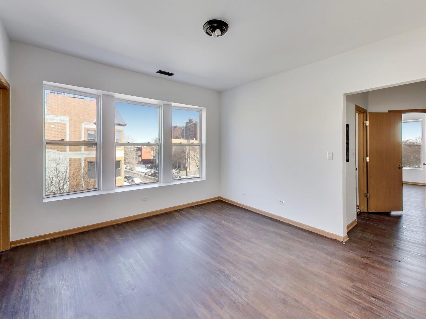 5000 South Champlain Avenue, Unit 3 Chicago, IL 60615 - Photo 3 of 17 an empty room with wooden floor and windows