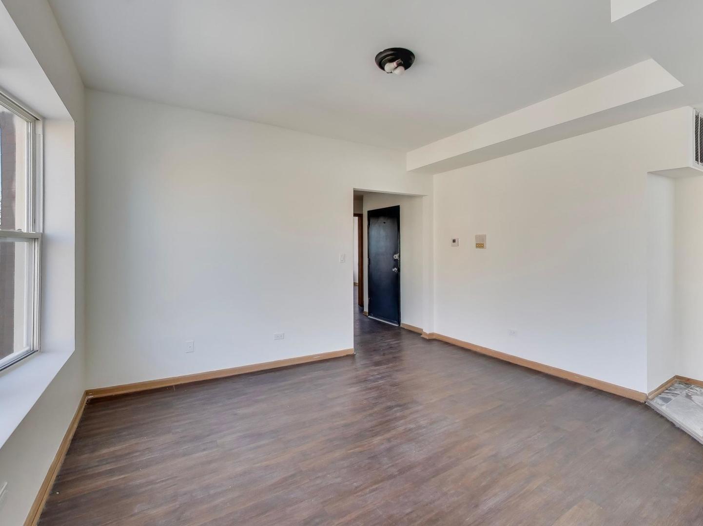 5000 South Champlain Avenue, Unit 3 Chicago, IL 60615 - Photo 5 of 17 a view of an empty room with wooden floor and a window