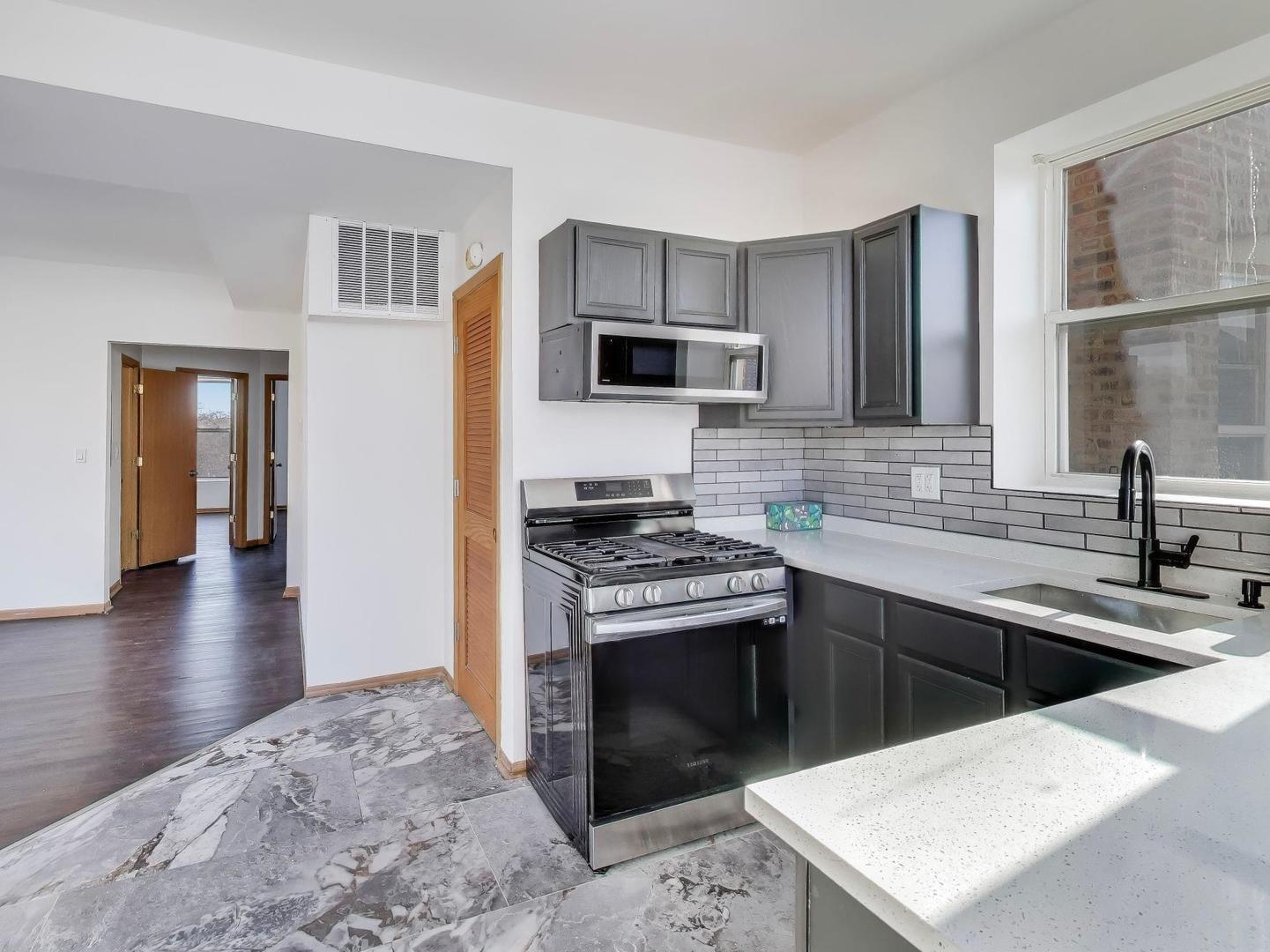 5000 South Champlain Avenue, Unit 3 Chicago, IL 60615 - Photo 6 of 17 a kitchen with a sink stove top oven and refrigerator